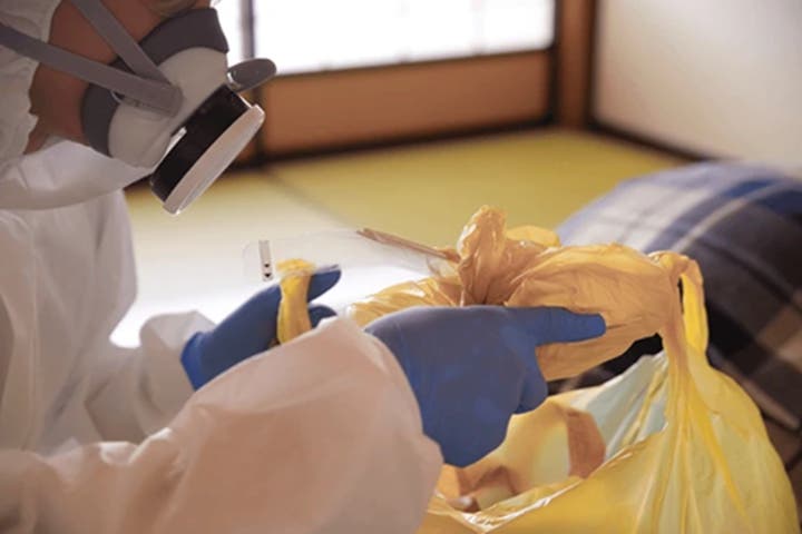 a person tying together a collection bag