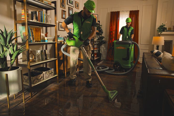 Two SERVPRO employees cleaning the floor in a residential home.