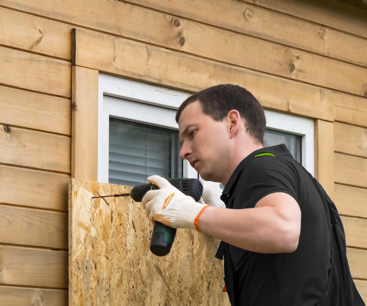 SERVPRO employee boarding-up a window at a home