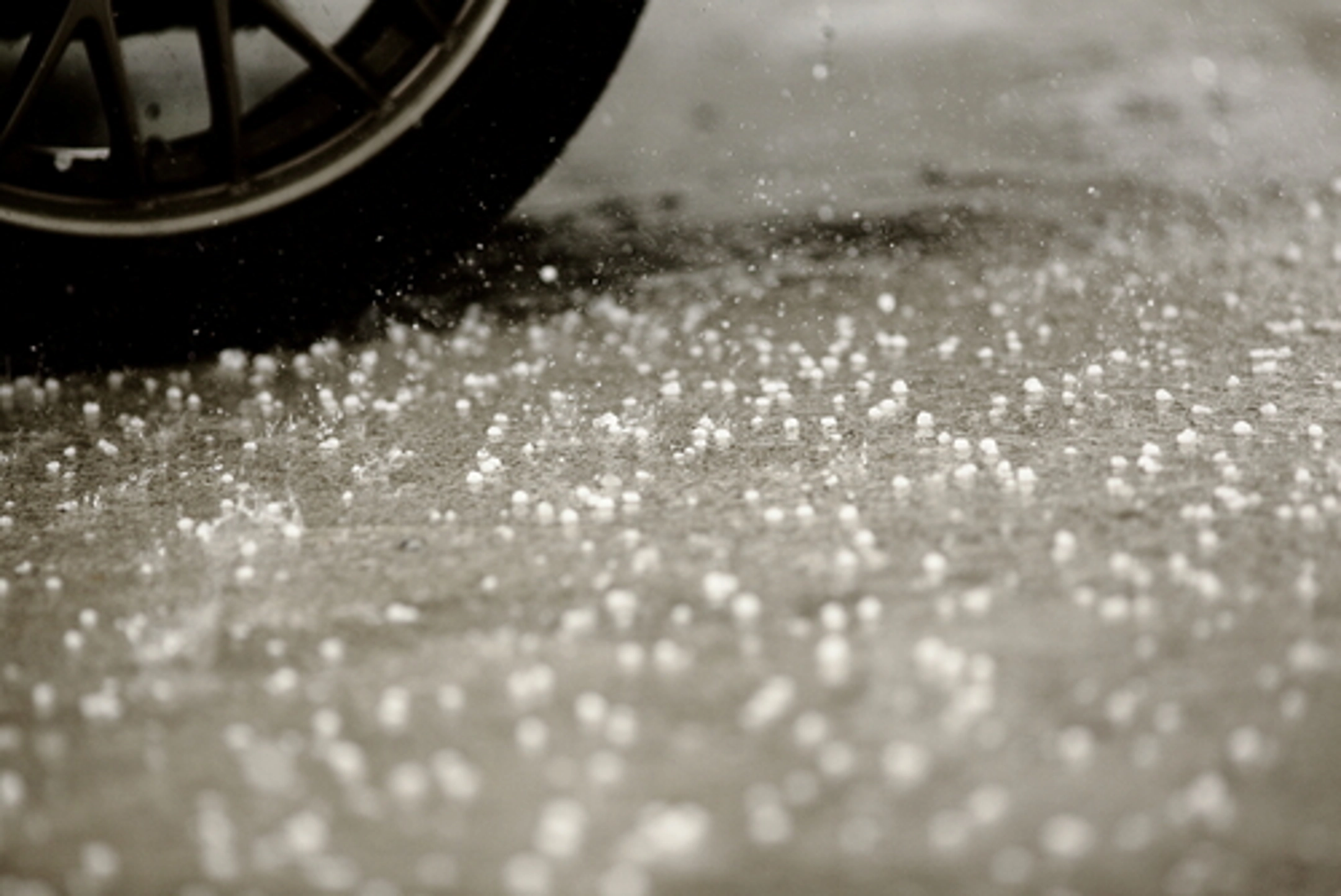 Hail falling by a car tire